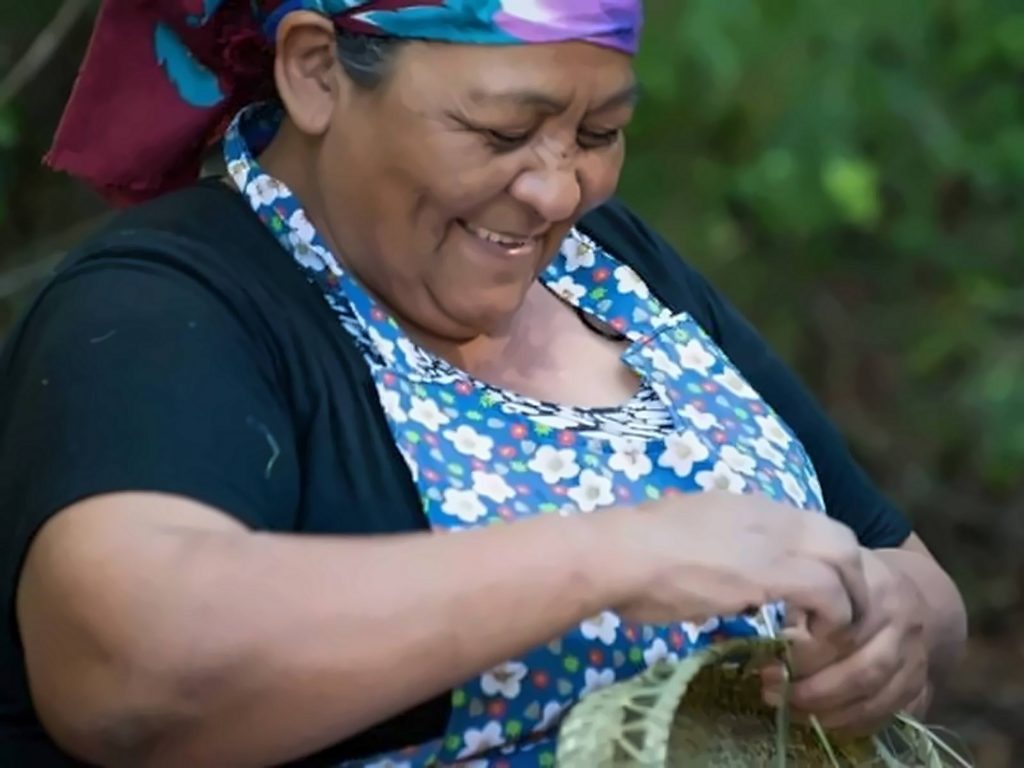 Conocer la artesanía local también está entre las opciones de qué hacer en Pucón, como el trabajo de esta artesana que teje un canasto de fibra vegetal.